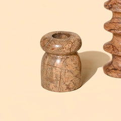Marble-patterned candle holders on a beige background