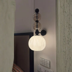 Sculptural wall sconce with carved alabaster panel and smoked glass globe
