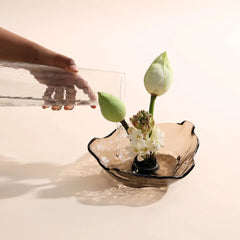 Lava Glass bowl in Dusk Brown color with flowers on a reflective surface