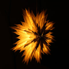 Star-shaped snowflake flower light with warm ambient light on a dark background