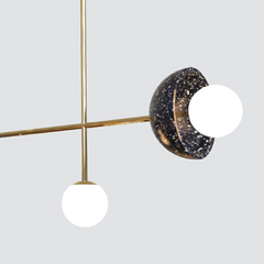 Modern pendant light with black speckled design and white spherical bulbs