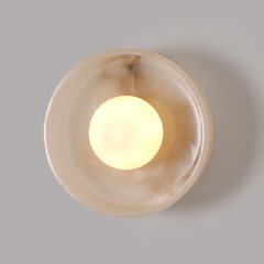 Front look of Blot Wall Sconce: mottled white stone dome with brass finish