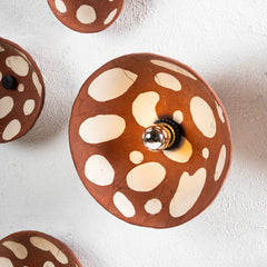Decorative wall light fixture with brown and white polka dot pattern crafted using terracotta and stoneware clay bodies