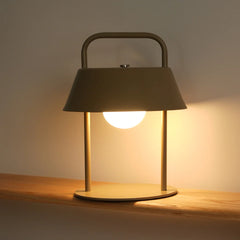 Portable Porto Table Lamp with a dark shade and wooden base on a wooden surface.