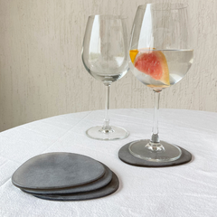 Set of Brown Frosted Glass Coasters Set of 4 with two water glasses on a white tablecloth.