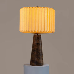 Decorative Hikari Table Lamp with warm glow showing round pleated shade and wooden base.