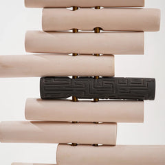 Floor Lamp close-up of curved stack of beige cylindrical objects with a black decorative bar