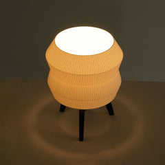Round, ribbed table lamp with a white interior on a dark background