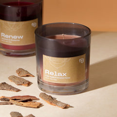 Relax Apple & Cinnamon Vegan Wax Scented Candle placed with "Renew" scented candle and cinnamon sticks on a table