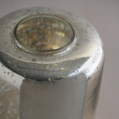 Close-up of silfr vase made of silver finish on glass with hand cut pattern with reflective surface