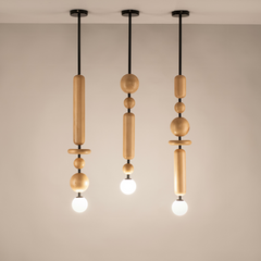 Three pendant hanging lights with wooden modules and black metal rods, suspended from the ceiling with a warm light glow.