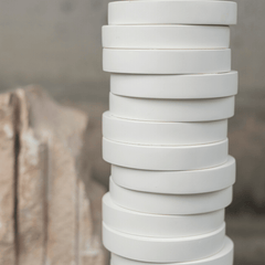 Close view white Yugen vase with more vases stacked in white