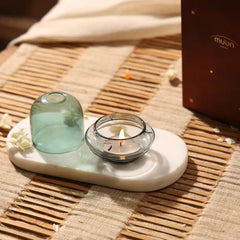 Muun Dome Tealight Holder in teal, dome and lit slate grey base side by side on white tray, front view