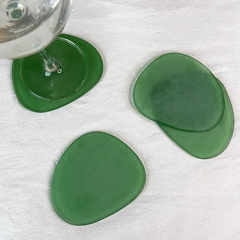 Green Frosted Glass Coasters Set of 4, placed next to each other along with a glass of water