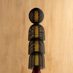 A black floor lamp with a geometric woven basket patterned shade design