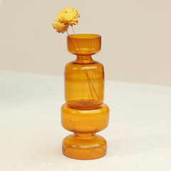 Two borosilicate glass mini vase placed on top of another vase with a small dried flowers.