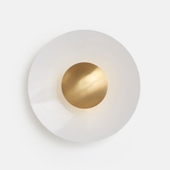 A Disc Wall Light with a white exterior and gold-colored interior light diffuser, mounted on a wall.