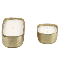 Fleur Votive in two different size gold candle holders with candles on a white background