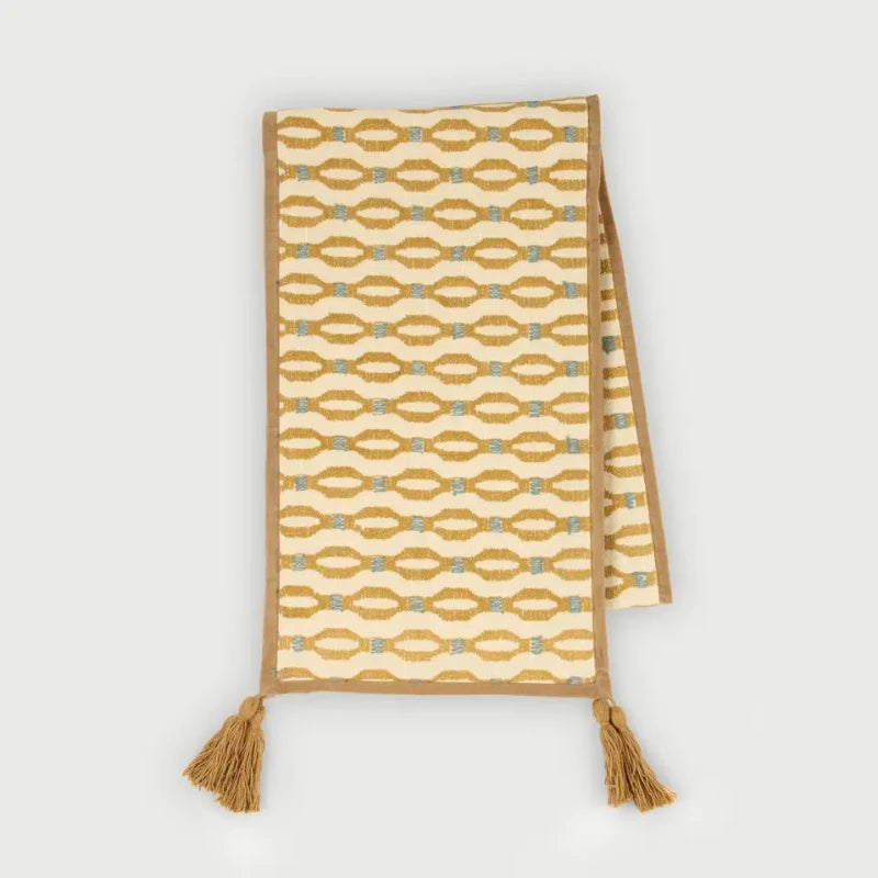 Poppy Ochre Table Runner laid flat, embroidered pattern with microvelvet border and tassels
