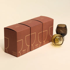 Set of three 'THEIA' boxes with glass candle holders placed next to it