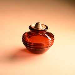 Red glass Kalash Oil Lamp with a metallic top on an orange background