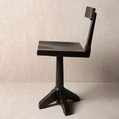 Side angle of modern black swivel barstool with a low rectangular seat, a tall integrated backrest.