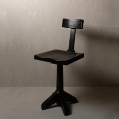 A modern black wooden chair with a curved seat, a backrest, and a four-star base.