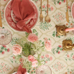 Eden Rose Linen Table Cover top view with pink roses, knotted napkin and brass candlesticks