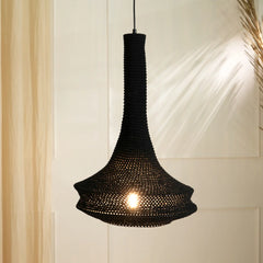 A black pendant lamp with a geometric print design, resembling a dome shape, hanging against a soft background.