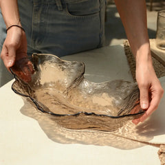 Person holding a large, decorative glass bowl in Dusk Brown color with natural patterns.