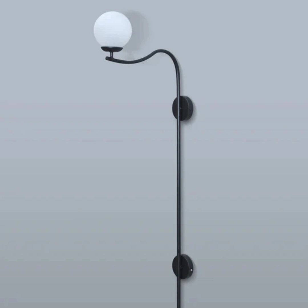 Black wall-mounted lamp with a curved arm on a light gray background