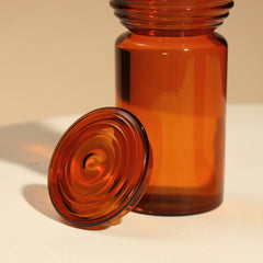 Amber Coil Glass Carafe with a matching lid on a beige background