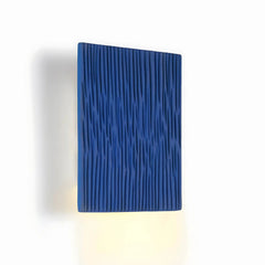 Blue ceramic textured wall light fixture on a white background