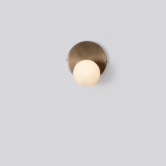 Stem wall sconce with a glass globe and brass dome