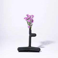 Decorative Black abstract vase with pink flowers on a white background
