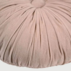 Round, pleated cushion in a soft pink color on a white background