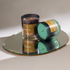 Balance Peppermint Vegan Wax Candle bottle is placed next to "Calm" scented candle on a reflective mirror