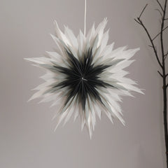 Decorative star-shaped snowflake flower light hanging against a wall