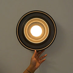 Detail shot of Discus Wall Light Black reclaimed teak wood material and LED globe light source