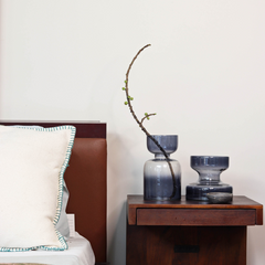 Decorative slate grey glass vases in 2 sizes, placed on a bedside table