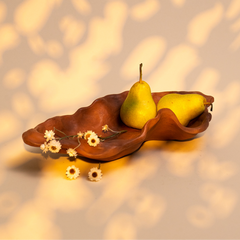 Brown kai organic bowl serveware with two pears and small flowers on a textured surface
