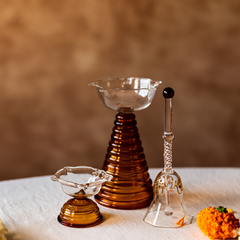 Three glass objects made of borosil glass on a textured surface with a blurred background
