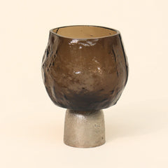 Tealight candle holder with sandcast metal textured surface on a beige background