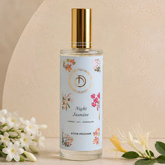 Illume - Room Freshener - 100 ML, Night Jasmine spray bottle with gold cap among jasmine flowers