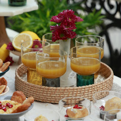 LIFT - Chaat Bowl or Drink Glass – glasses filled with orange juice on a rattan tray at a brunch table