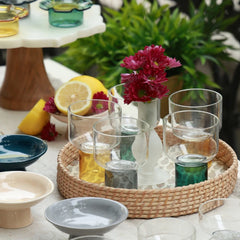 LIFT - Chaat Bowl or Drink Glass – empty yellow, clear black and teal base glasses on a rattan tray with red flowers