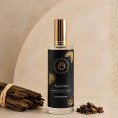 Illume - Room Freshener - 100 ML, Royal Oud black label spray bottle beside agarwood pieces