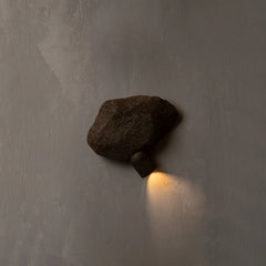 Dark stone wall light fixture on a textured gray wall