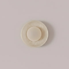 Blot Wall Sconce Small, compact half-round mottled stone dome, front view
