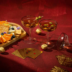Two cocktails Ratri Coupe Glasses & playing cards.